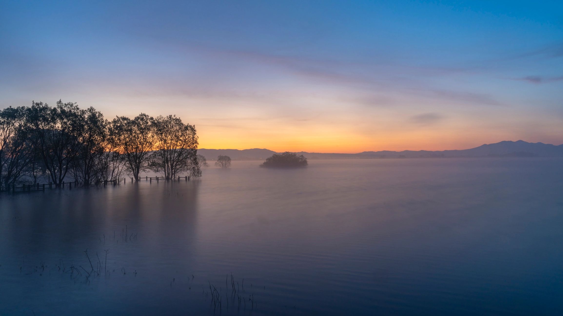 Moody lakeside landscape with distant mountains